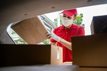 Asian delivery post man wearing face mask deliver box to customer.