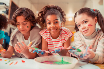 Happy children painting with their fingers at school
