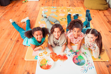 Group of happy children making experiments with paint