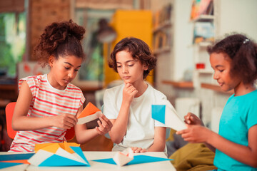 Group of classmates learning to make origami