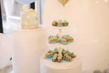 Candy bar. Blue decorated cake standing of festive table with deserts