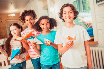 Happy kids holding their bright paper crafts