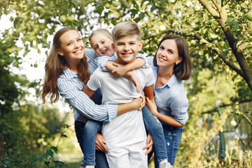 Obraz premium Family in a park. Children near apple tree. Woman in a blue shirt