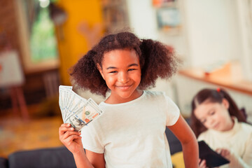 Smiling little girl holding a pile of banknotes