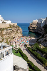 People relax and swimming on lovely beach Lama Monachile in Polignano a Mare, Adriatic Sea, Apulia, Bari province, Italy,