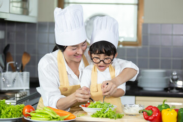 Happy family Asian woman young mother with son boy cooking healthy salad for the first time. first lesson and healthy lifestyle concept.
