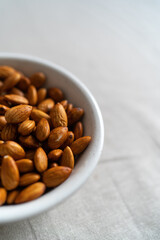 Plate with almonds on a light surface