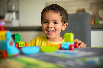 Fototapeta na wymiar young boy playing home with blocks