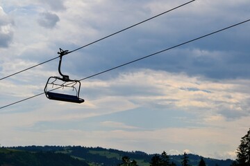 Mountain chairlift. 4-seater chairlift. The ski lift going tothe station. Close up of an empty four person chair lift hanging at a ski lift wires