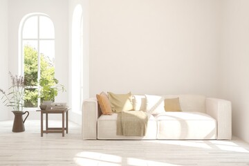 Fototapeta premium White living room with sofa and summer landscape in window. Scandinavian interior design. 3D illustration