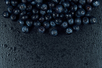 Freshly juicy picked blueberries on dark background. Top view. Selective focus. Free text space. 