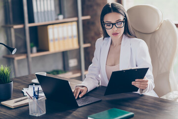 Photo of attractive business lady hold clipboard read contract typing notebook table information staff colleagues partners home office social distance formal wear specs suit indoors