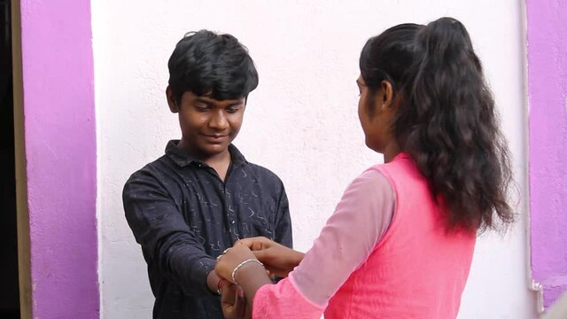 Portrait of an Indian sister tying rakhi to her brother during the Raksha bandhan festival
