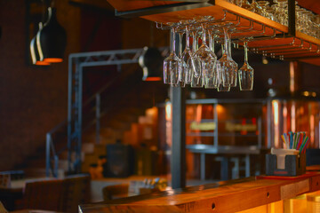 A lot of empty clean glasses in bar. Blurred restaurant background. Design banner with copy space.