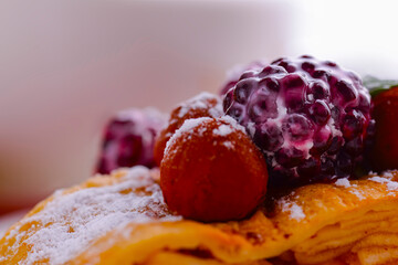 Cake of puff pastry with raspberry and chocolate. Selective focus on a berry. Blurred background.