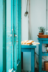 Vertical image of baked goods displayed in a turquoise themed cafe which recently opened in San Telmo neighborhood.