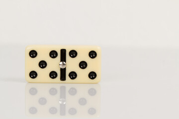 Close up of domino pieces with black dots isolated in white background with reflection