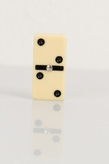 Close up of domino pieces with black dots isolated in white background with reflection