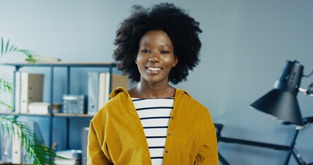 Happy African American female working in office. Beautiful young african american girl posing and looking at camera.