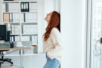 Young woman relaxing against a wall in the office