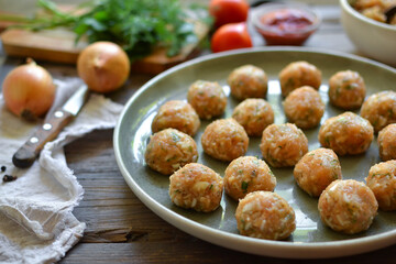 Chicken meatballs recipe. Step by step cooking. Raw chicken meatballs on a gray platter. Wooden background