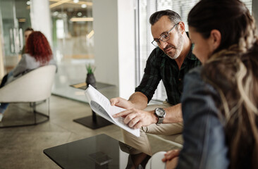 Mature businessman going over paperwork with an office colleague