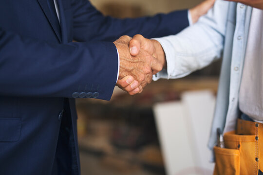 Two adult man shaking hands.