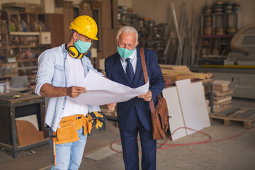Carpenter showing blueprints to his manager