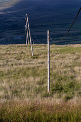 Fototapeta na wymiar Telegraph poles on the hills overlooking the village of Cwmllynfell in the Swansea Valley, South Wales UK 