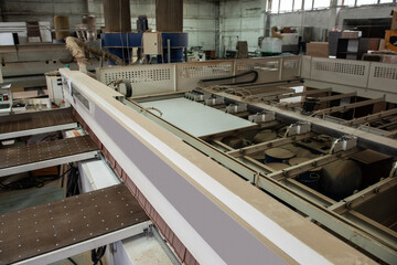 Fototapeta premium Wooden furniture production. Industrial cutting machine for automatic wood cutting