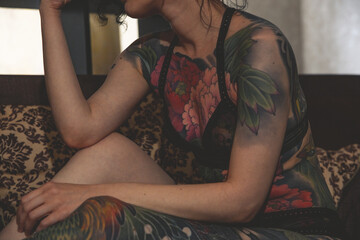 Fototapeta premium tatoo girl on the sofa in home