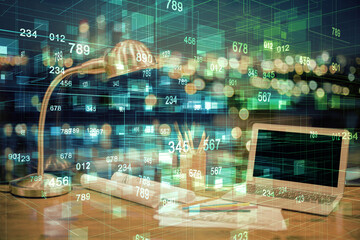 Double exposure of table with computer on background and data theme hologram. Data technology concept.