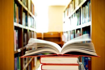 Opening book or textbook with bookshelf in the library.Education concept.	
