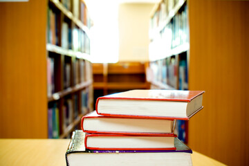 Concept of education.Stack of book on the  table with bookshelf.