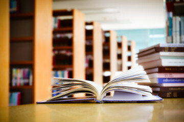 Opening book or textbook with bookshelf in the library.Education concept.