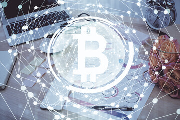 Double exposure of blockchain and crypto economy theme hologram and table with computer background. Concept of bitcoin cryptocurrency.