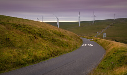 Wind turbines and a winding road on the Betws mountain in South Wales, UK © leighton collins