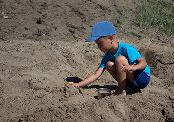 
boy playing in the sand by the river