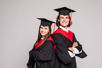 Portrait of two happy graduating students isolated over white background.