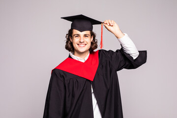 Young male graduation portrait smiling and standing over a white background