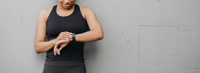 Healthy lifestyle and sport. Woman is happy with result of jogging and looks at fitness tracker