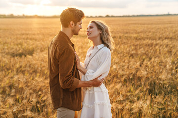 Image of young couple hugging together in golden field on countryside