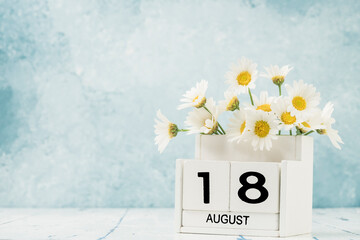 White cube calendar for august decorated with daisy flowers