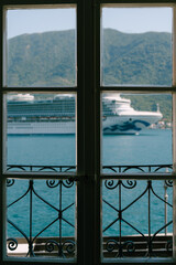 The cruise liner sails in the window of the hotel room.