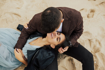 Portrait of smiling beautiful girl and her handsome boyfriend. Woman in tender blue dress. Happy cheerful couple. Happy smiling couple in suit and dress on sandy beach.