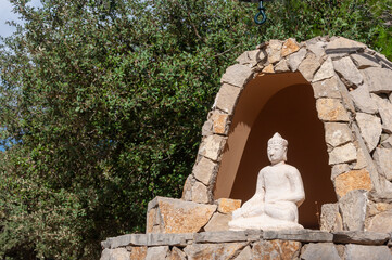 Plaster replica of a Buddhist figure in a stone structure