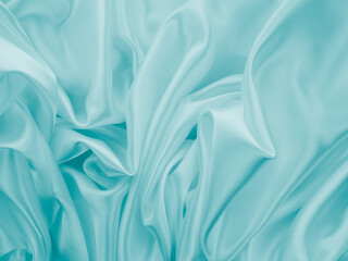 Beautiful elegant wavy turquoise silk or satin luxury cloth fabric texture, abstract background design.