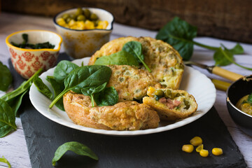An omelette with sweet corn, green peas and spinach.