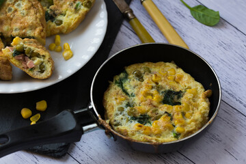 An omelette with sweet corn, green peas and spinach.