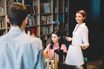 Positive woman laughing while communicating with colleagues and discussing creative ideas for developing design project.Cheerful female architect teamworking with professionals in stylish office